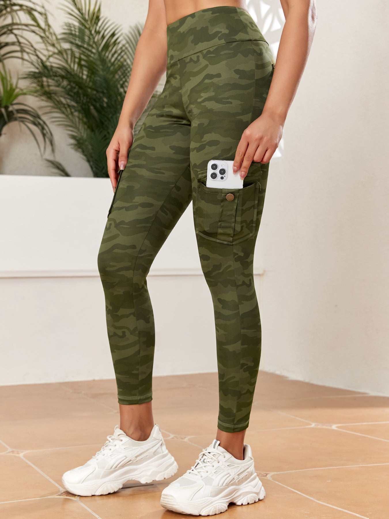 Person wearing green camouflage leggings with a white background