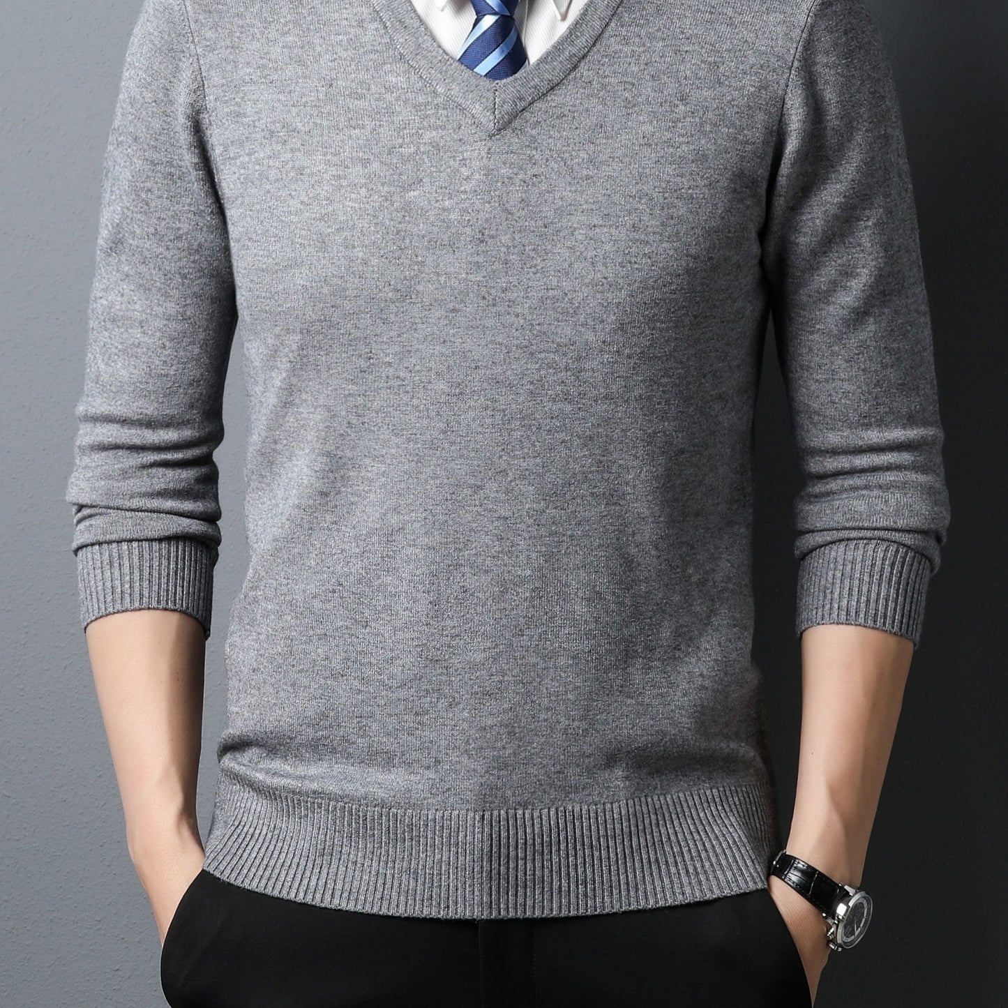 Person wearing a gray Men's Knitted V-neck Sweater with a dark background