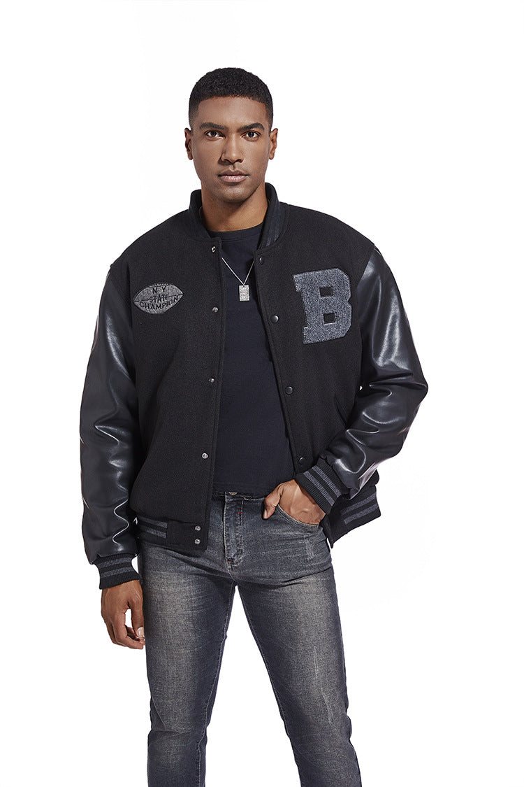Man wearing a black varsity American Baseball Jacket with leather sleeves on a white background