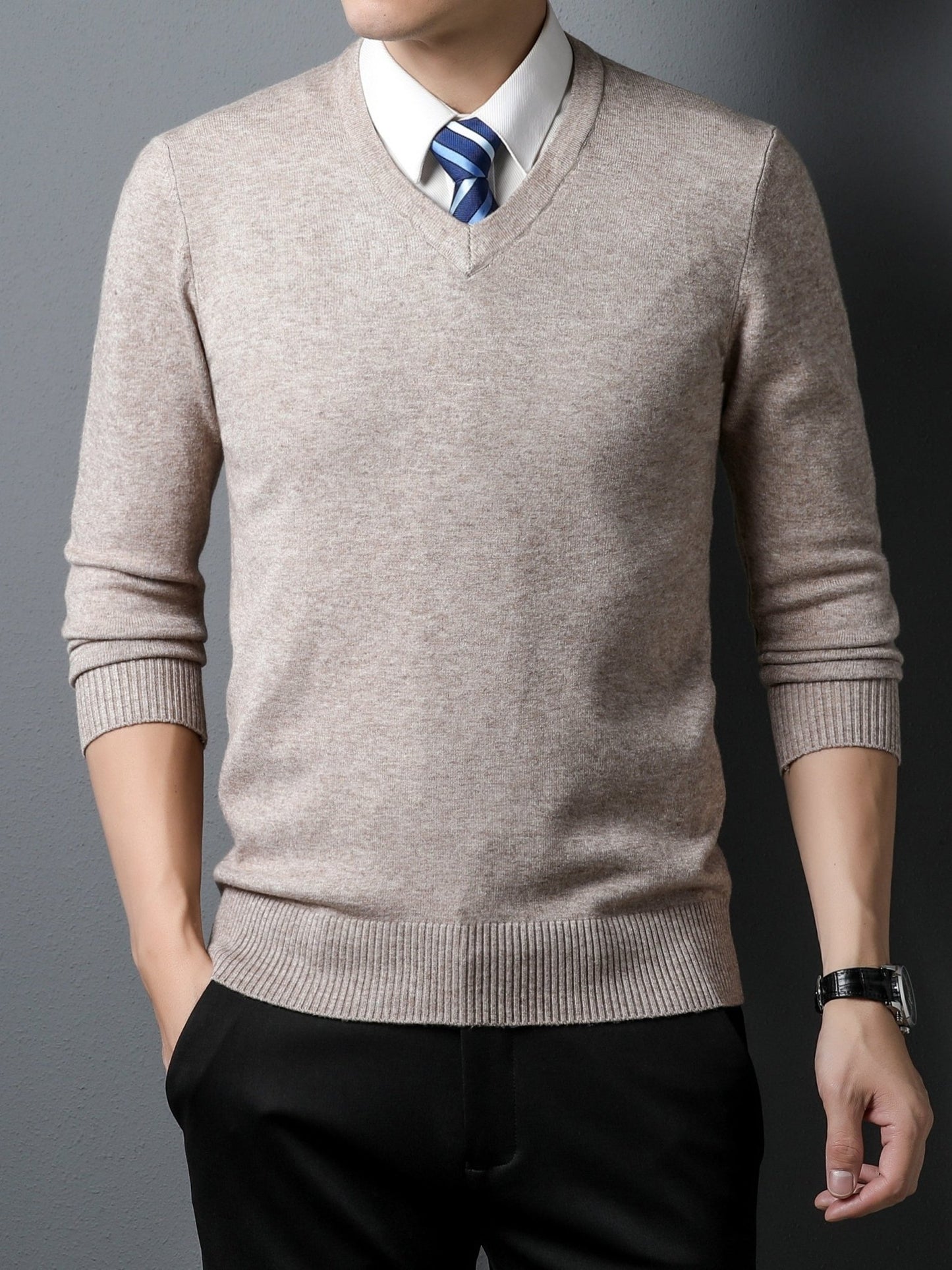 Man wearing a beige Men's Knitted V-neck Sweater over a white shirt with a blue tie against a gray background