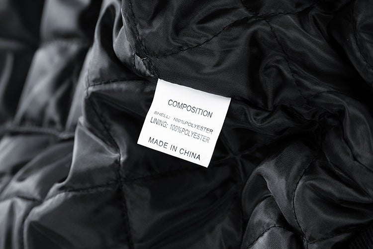 Close-up of a black American Baseball Jacket with a label displaying composition and manufacturing details.