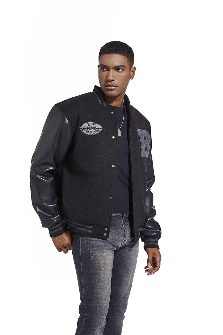 Man wearing a black varsity American Baseball Jacket with leather sleeves on a white background