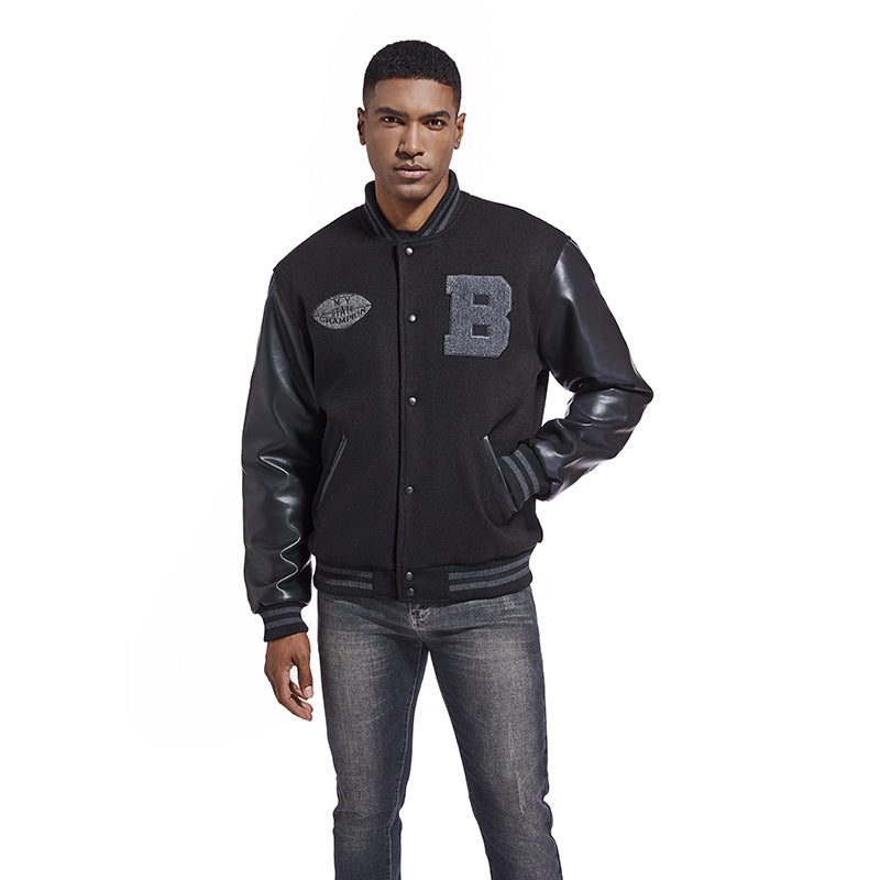 Man wearing a black varsity American Baseball Jacket with leather sleeves on a white background