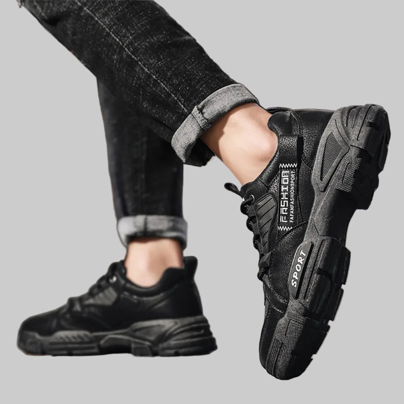 Black athletic shoes worn with rolled-up jeans on a blurred background