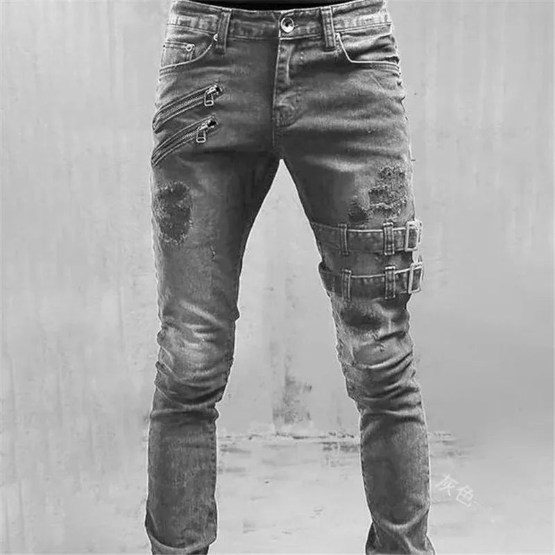Distressed black jeans with metal accents on a gray background