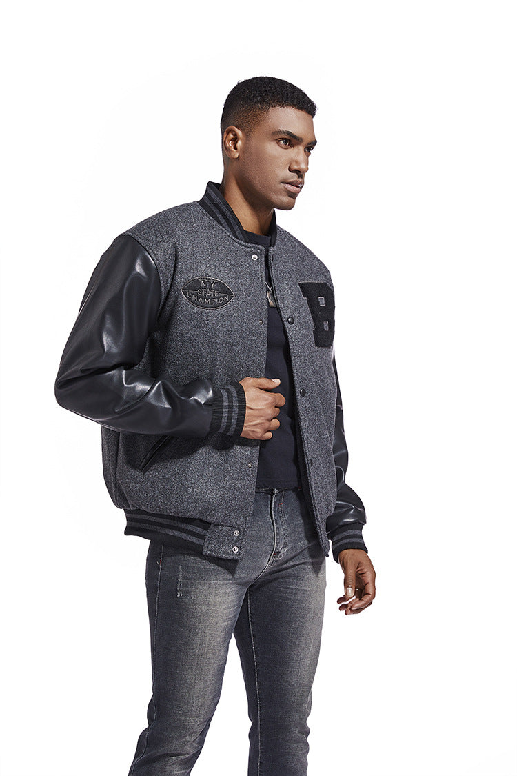 Man wearing a gray varsity American Baseball Jacket with leather sleeves on a white background